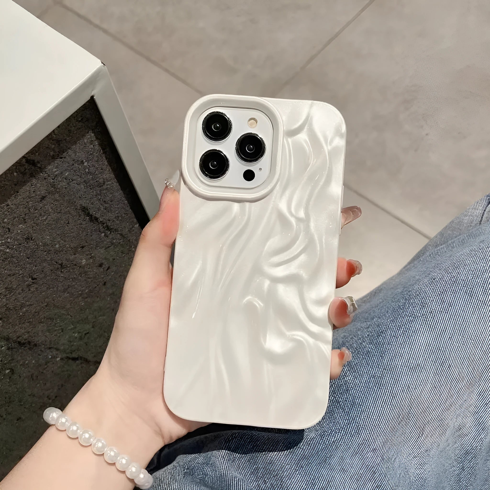 Ins-style water ripple silicone phone case for iPhone in milky white, showing textured surface.