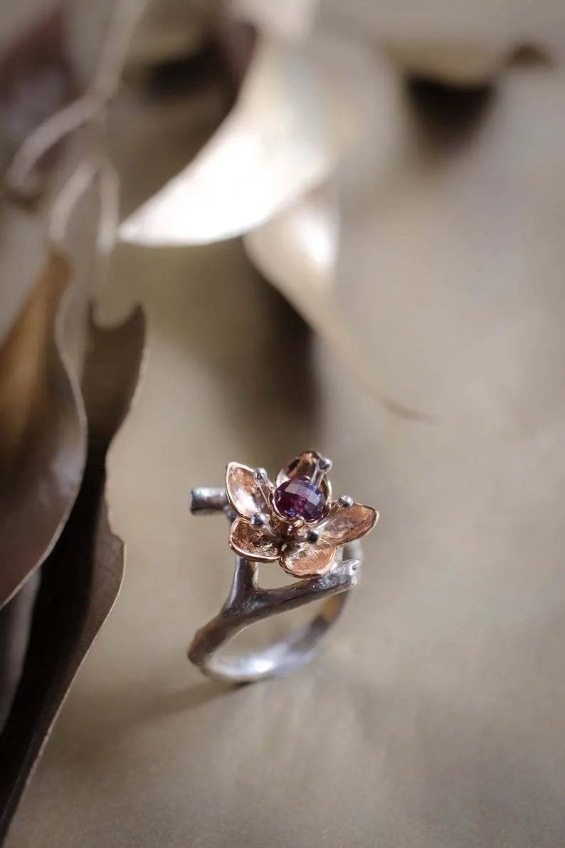 Silver two-tone geometric floral fashion ring for women on a hand.