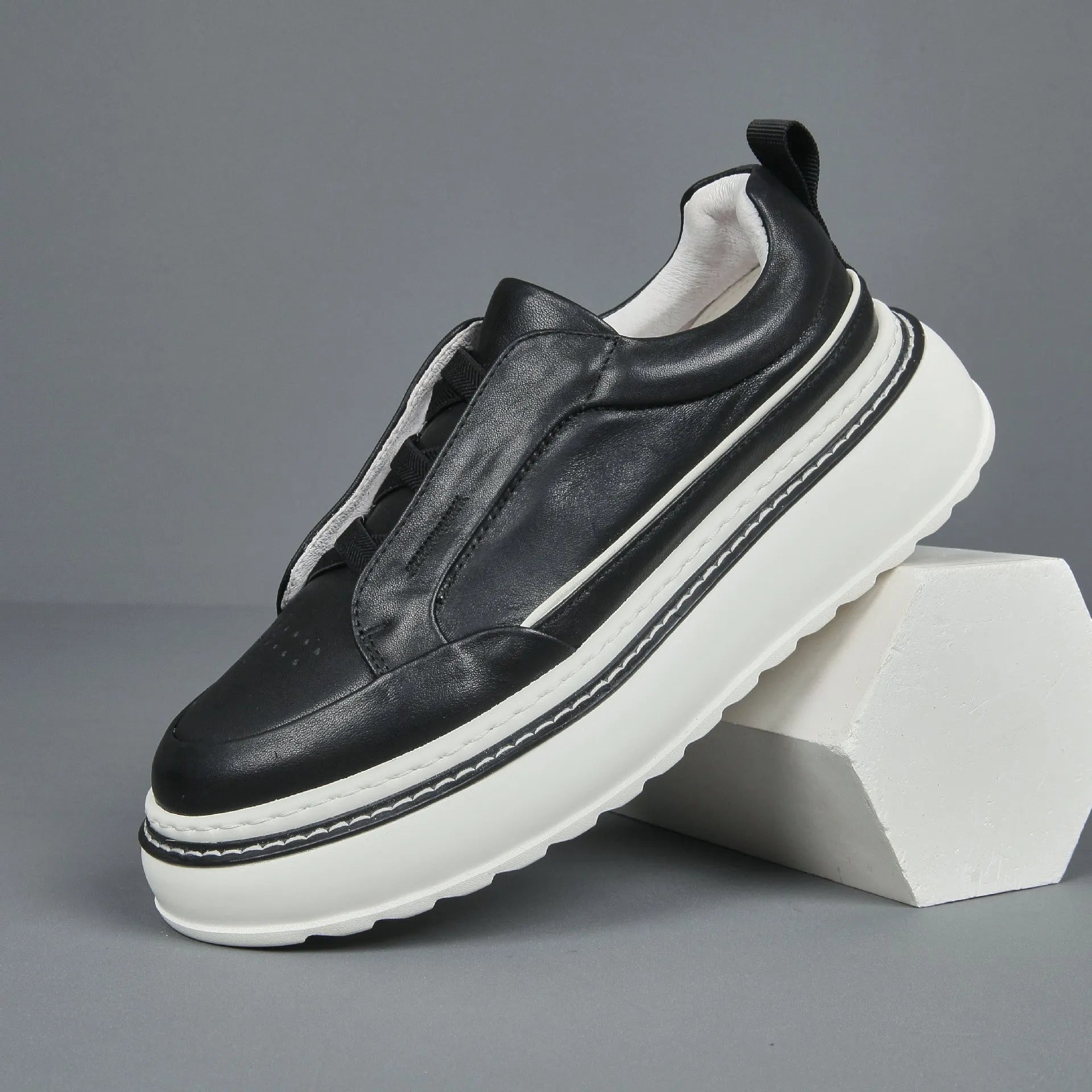 Breathable casual slip-on sneaker in black with first layer cowhide upper, platform mid heel, and sewing thread detail