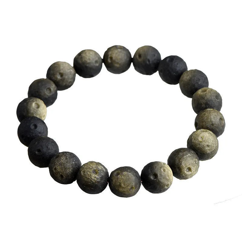 Natural obsidian crater ball bracelet with textured beads in silver stone meteorite colour on a wrist.