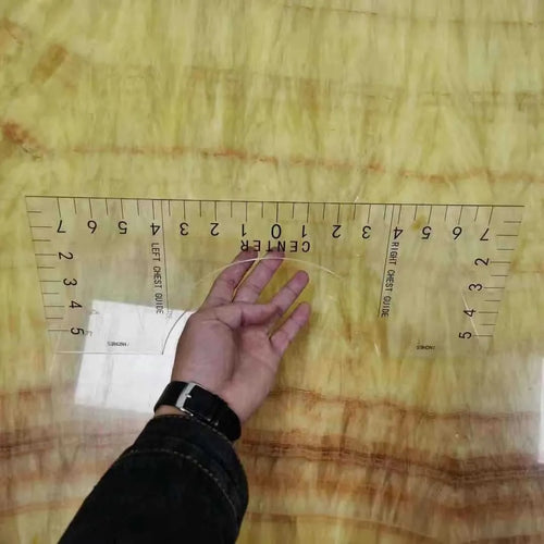 Transparent acrylic sewing ruler template for T-shirt patch alignment showing etched measurement markings