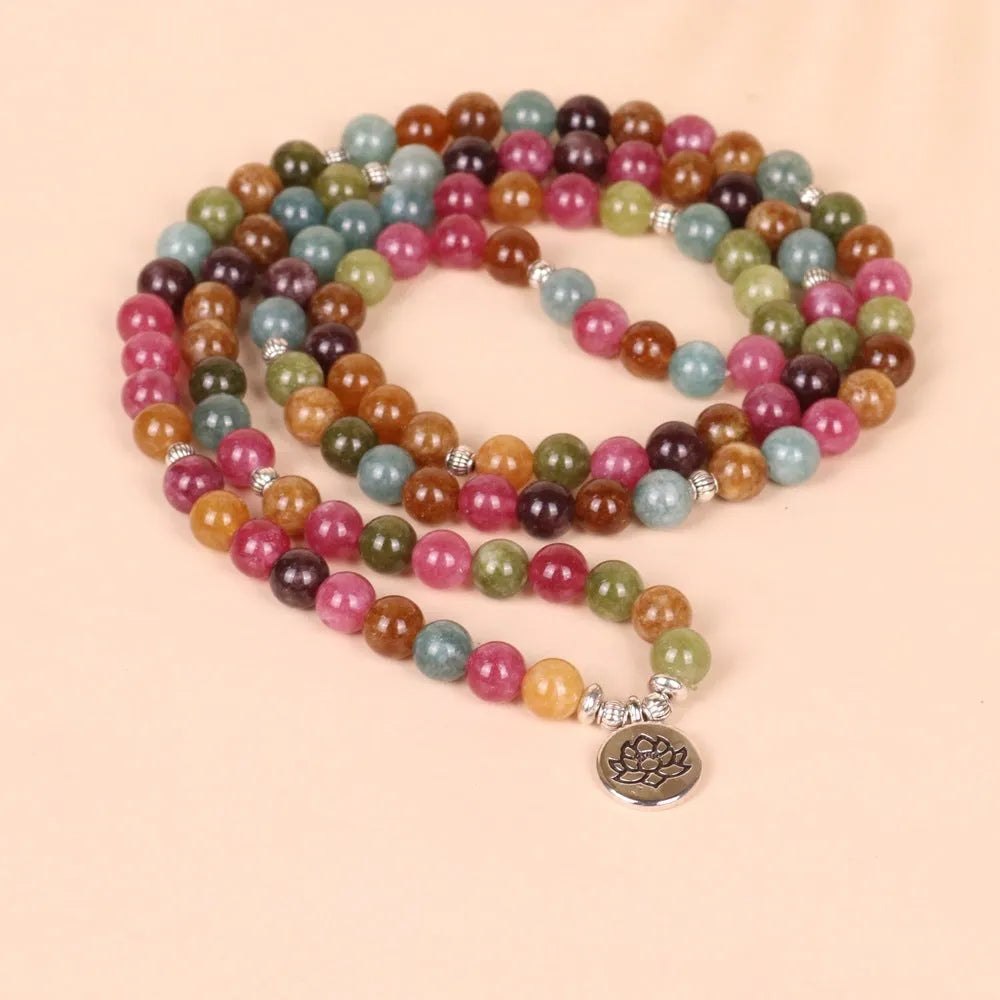 Close-up of a Tourmaline-coloured alloy bracelet with 108 beads and a central hanging lotus decoration.