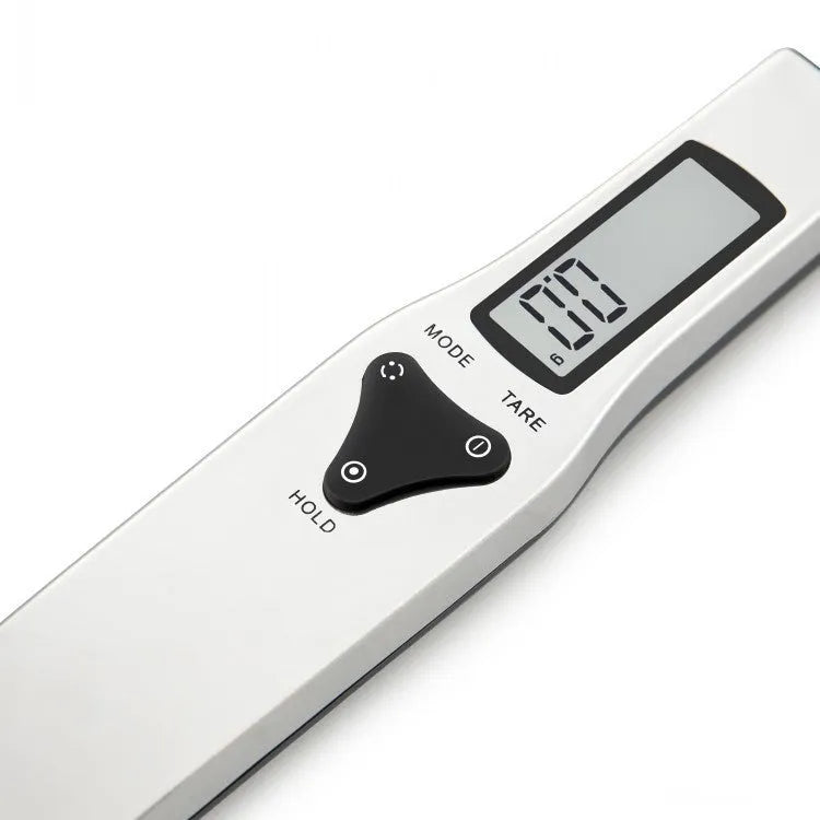 Smart digital measuring spoon with integrated display showing weight, next to AAA batteries.