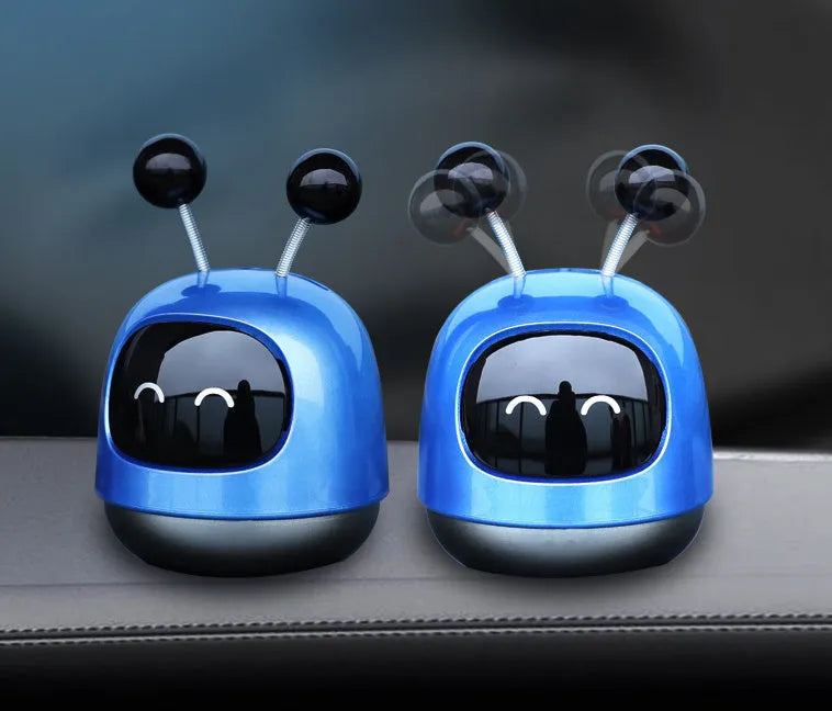Robot-shaped car vent air freshener ornament in blue, grey or red with gel fragrance.