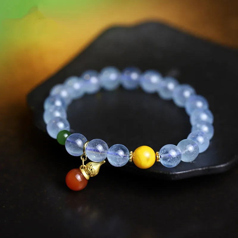 Geometric women's bracelet with 8mm iced aquamarine stones on a wrist.