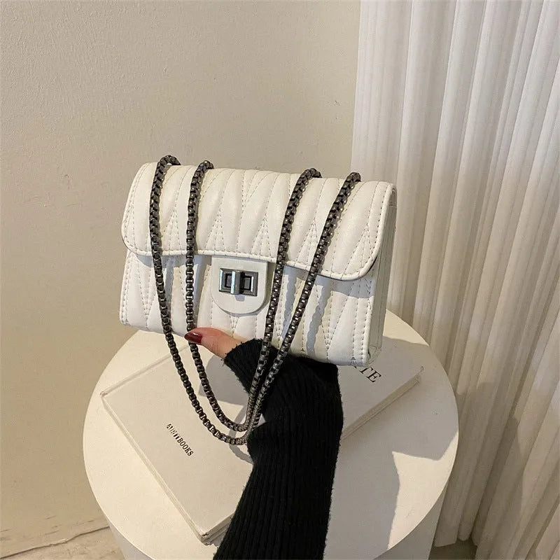 Women's small retro textured square shoulder bag in PU showing interior phone pocket and soft handle.