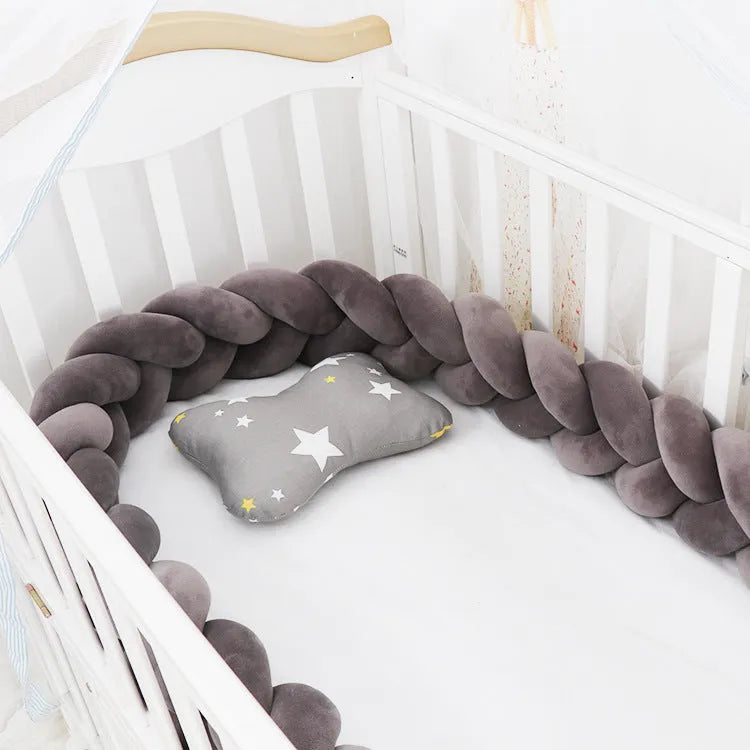Bendable braid knot baby crib bumper in spandex velvet fabric on a white cot.