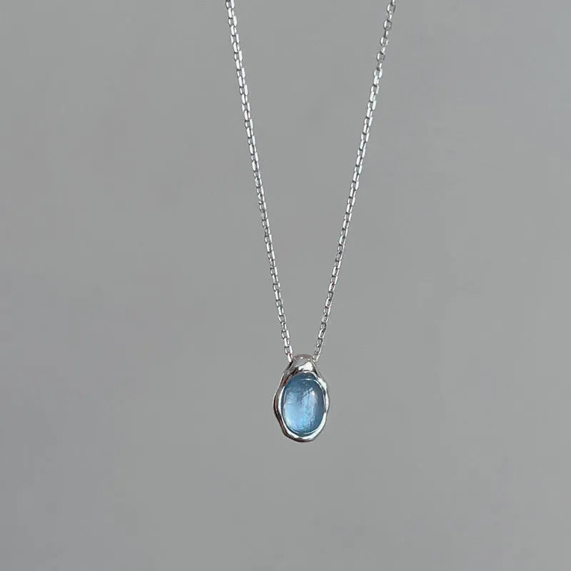 Geometric navy blue water drop pendant on an adjustable platinum-colour cross chain necklace.