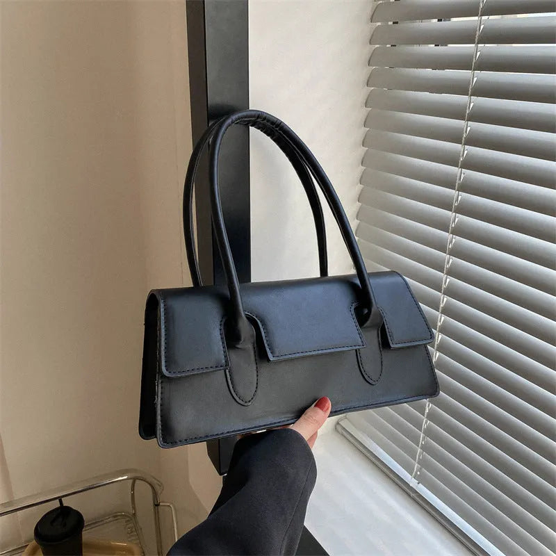 Women's small square shoulder bag in PU leather showing document compartment interior and stitching detail