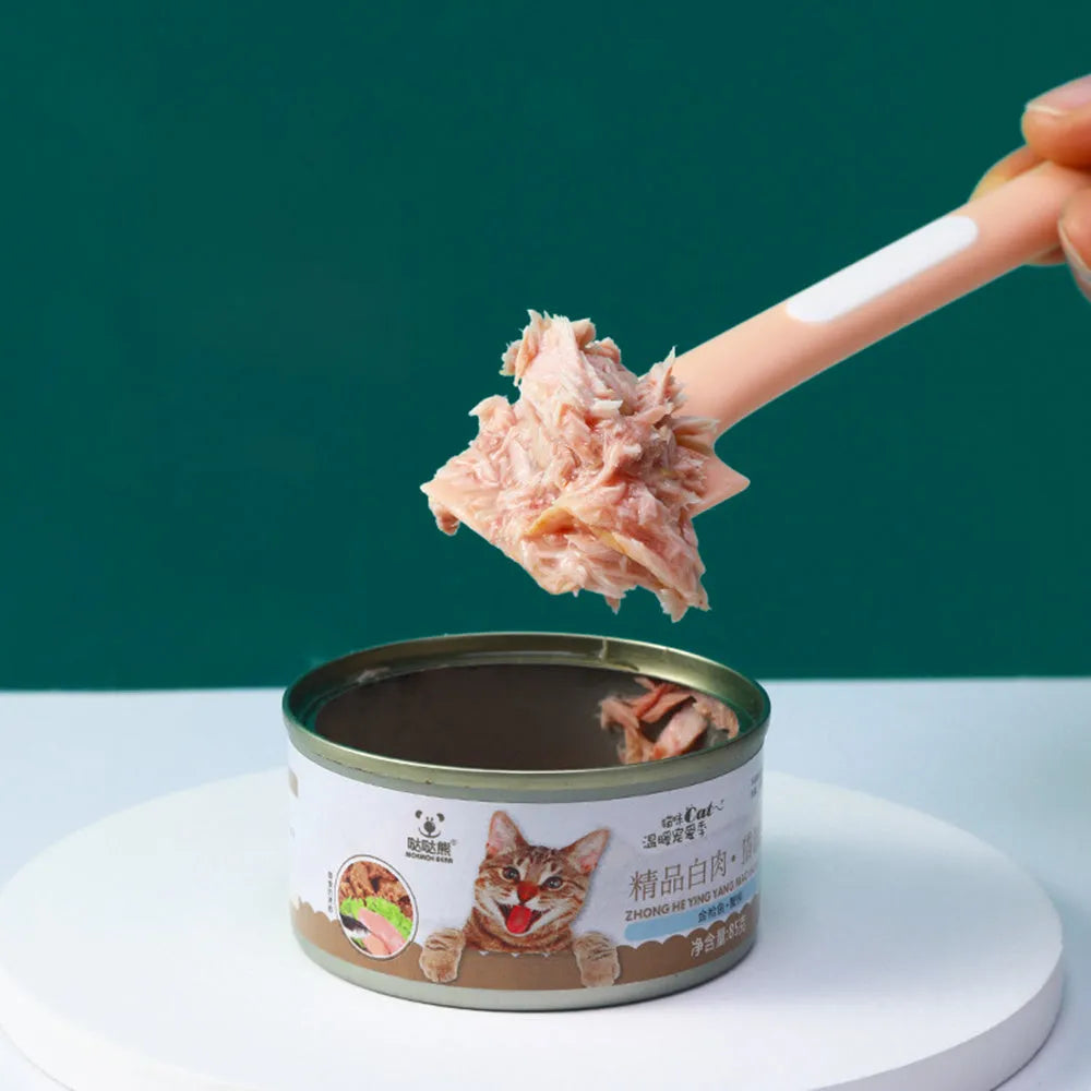 Green pet feeding spoon with long handle and right-angle edge for scraping canned dog or cat food.