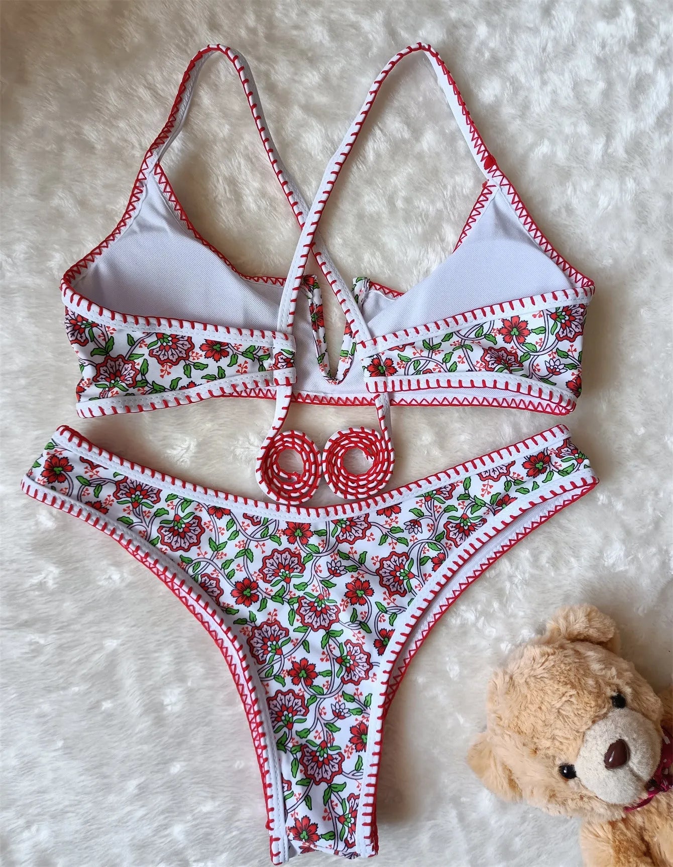 Women's one-piece swimsuit with V-neck embroidery and floral print on blue background.