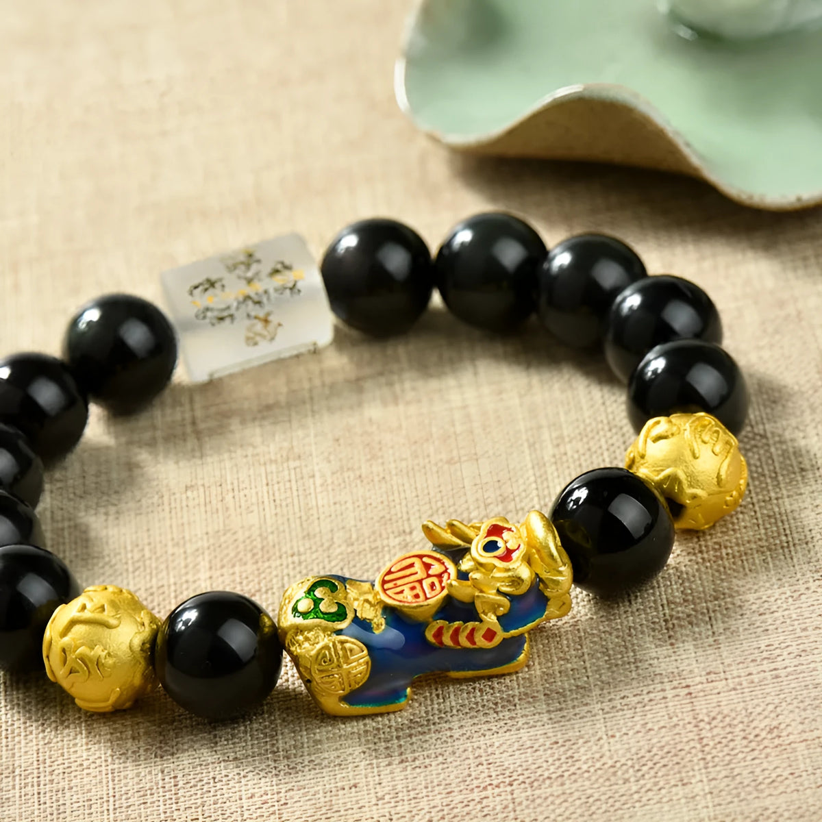 Natural obsidian temperature-sensitive colour change bracelet with gold accents and Pi Xiu motif