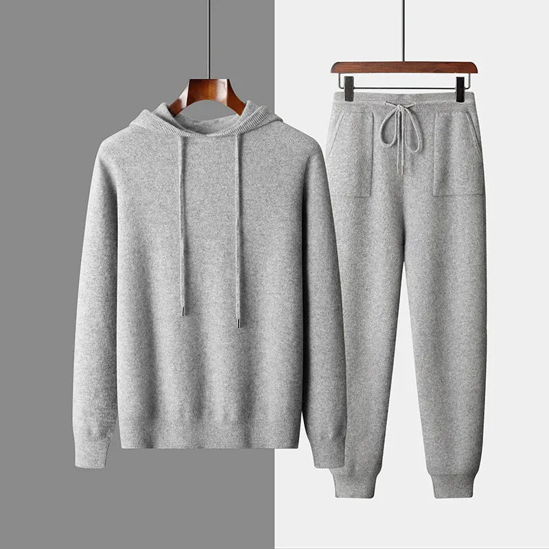 Man wearing a light grey cashmere hooded sweatshirt and matching trousers, a casual winter two-piece set.