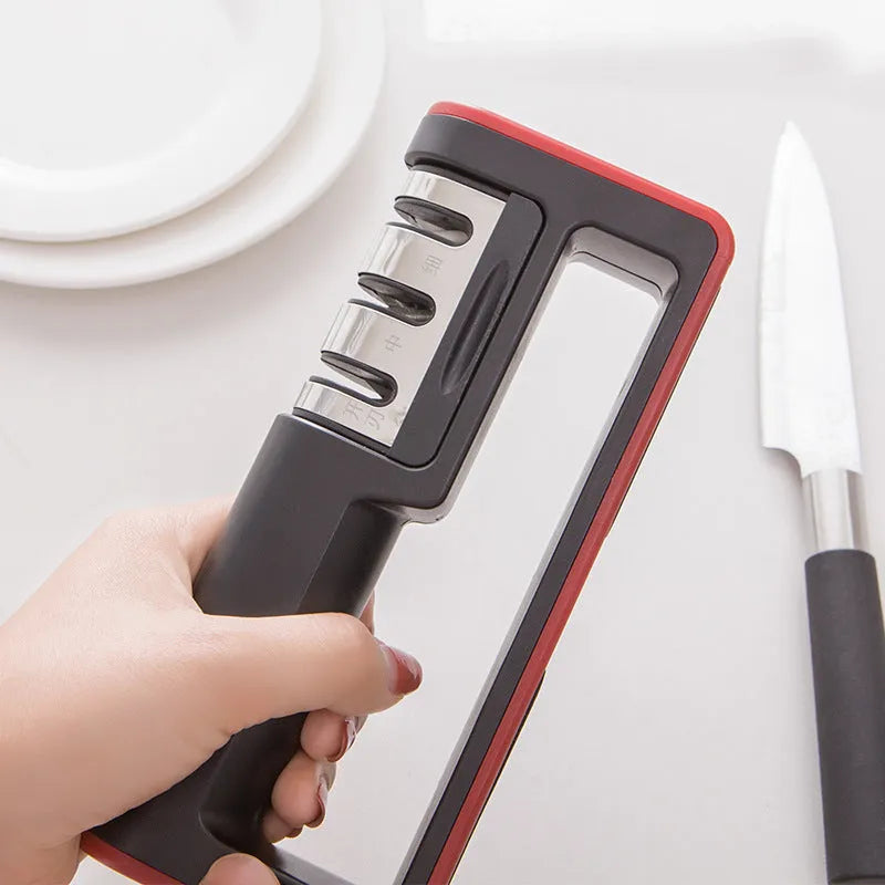Black and red three-stage professional knife sharpener on a kitchen counter