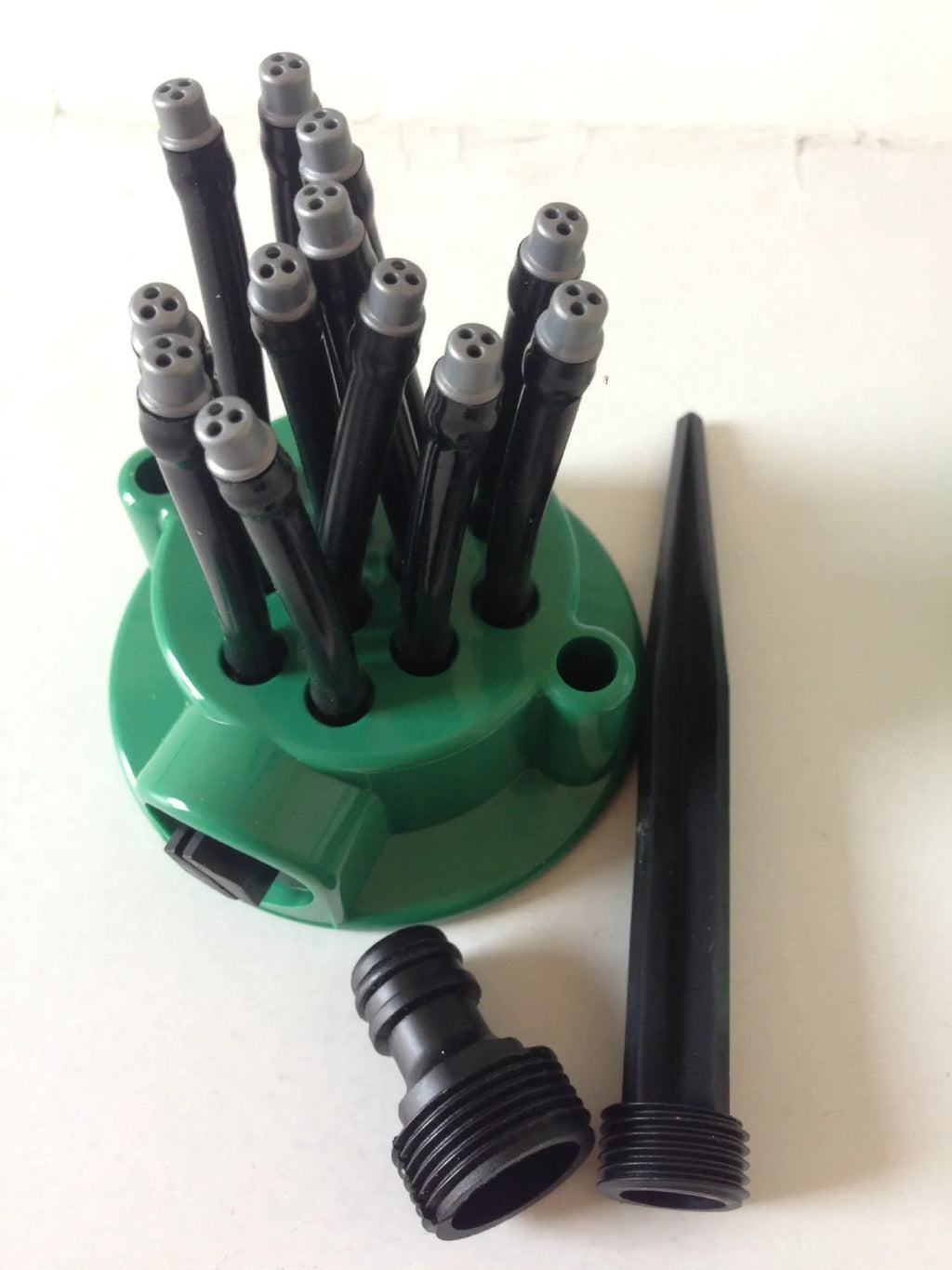 Green adjustable lawn sprinkler with flexible watering noodles on a 9cm base.