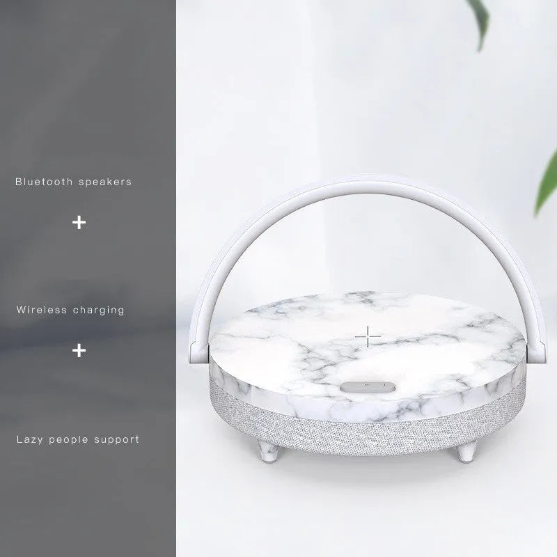 Wireless charging LED night lamp with Bluetooth speaker in marble pattern finish showing phone on charging surface