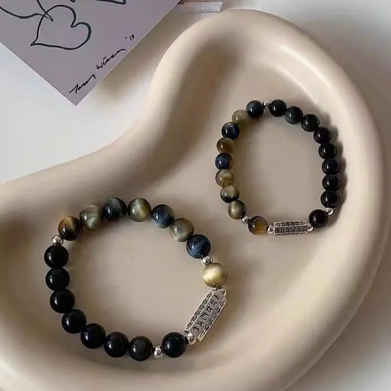 Sterling silver bracelet with obsidian and tigereye stone beads showing geometric round design and mantra engraving