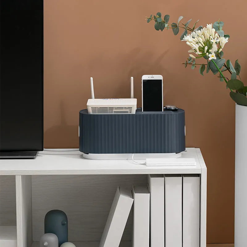 Blue and white power strip storage box with lid open showing cable holes and phone slot.