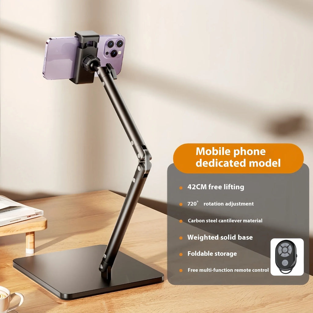 Silver alloy desktop phone bracket with double arms holding a smartphone, shown with a remote control on a wooden desk.