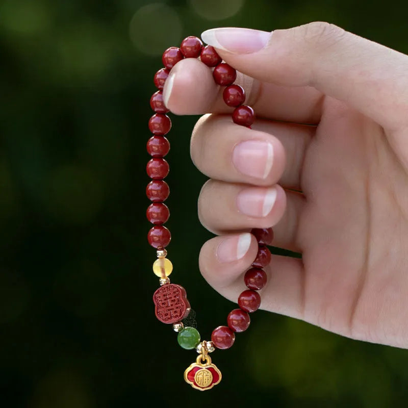 Emperor Sandstone Happy Eyebrow Bracelet with cinnabar accents and fu character charm on wrist.