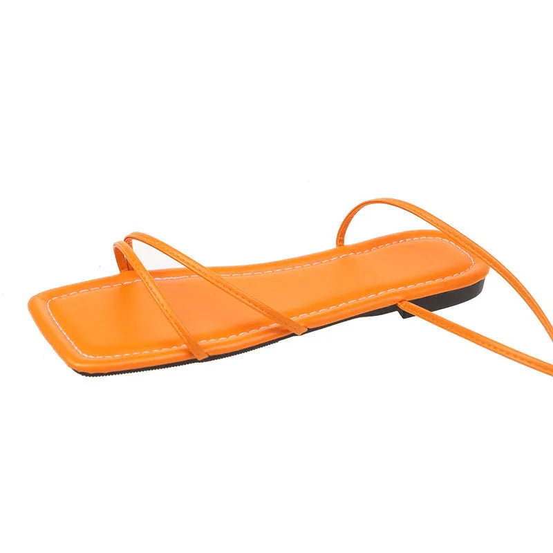 Women's white flat sandals with ankle bandage strap and front lace-up on a square toe.