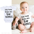 White triangle climbing baby bodysuit with black text reading 'Silly Daddy Boobs Are For Babies'