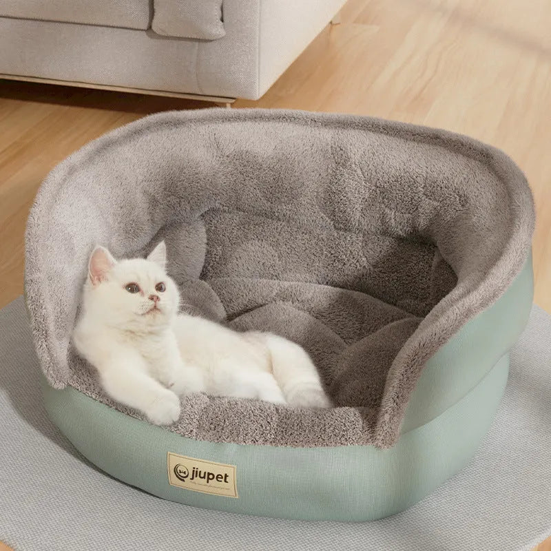 Green cloth sofa-style dog kennel with matching blanket, size M, on a wooden floor