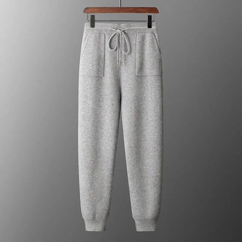 Man wearing a light grey cashmere hooded sweatshirt and matching trousers, a casual winter two-piece set.