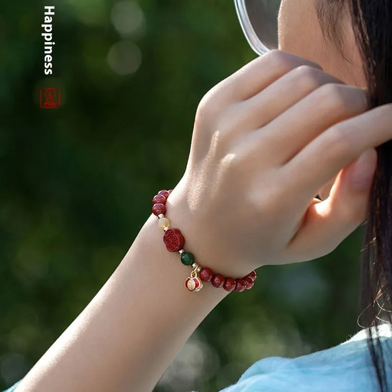 Emperor Sandstone Happy Eyebrow Bracelet with cinnabar accents and fu character charm on wrist.