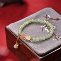 Qingshui jade bracelet with gold plated gourd charm and fu character pendant on adjustable cord