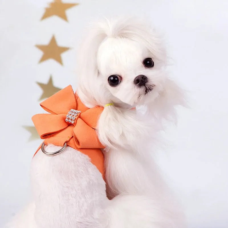 A pink microfiber dog chest strap with a large decorative bowknot and metal buckle.
