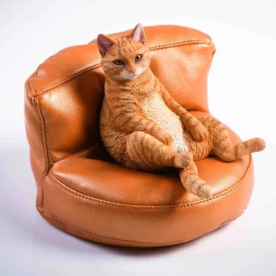 Resin lazy cat car ornament with fabric sofa, approximately 7.5cm high.