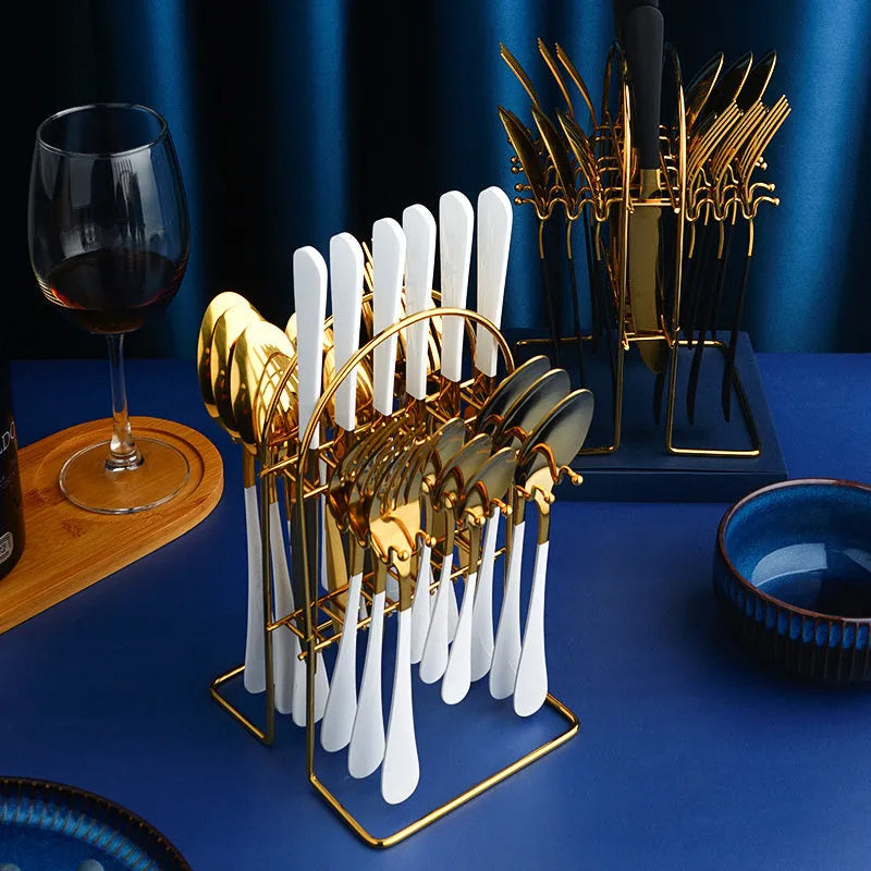 Gold stainless steel knife fork spoon cutlery set with storage rack on a table.