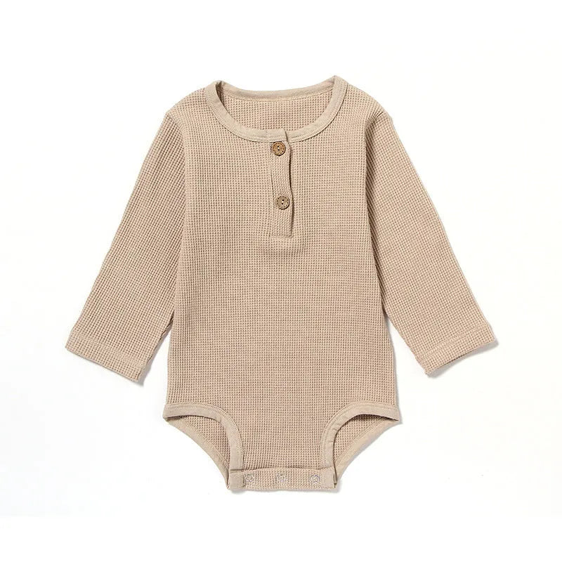 Long sleeve waffle cotton baby romper in neutral colour on hanger