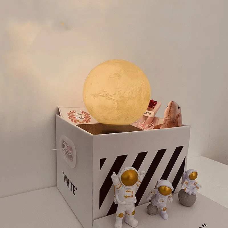Maglev floating planet night light with astronaut figures on a base, showing USB cable.