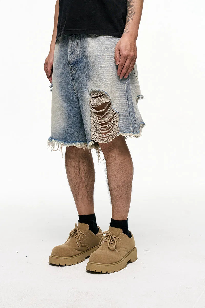 Men's light blue baggy denim shorts on a neutral background, showing wide leg and mid waist.