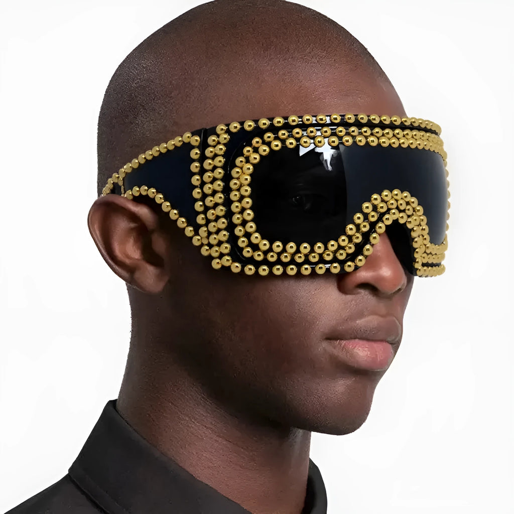 Men's square punk sunglasses with large rim and silver rivets on a dark background.