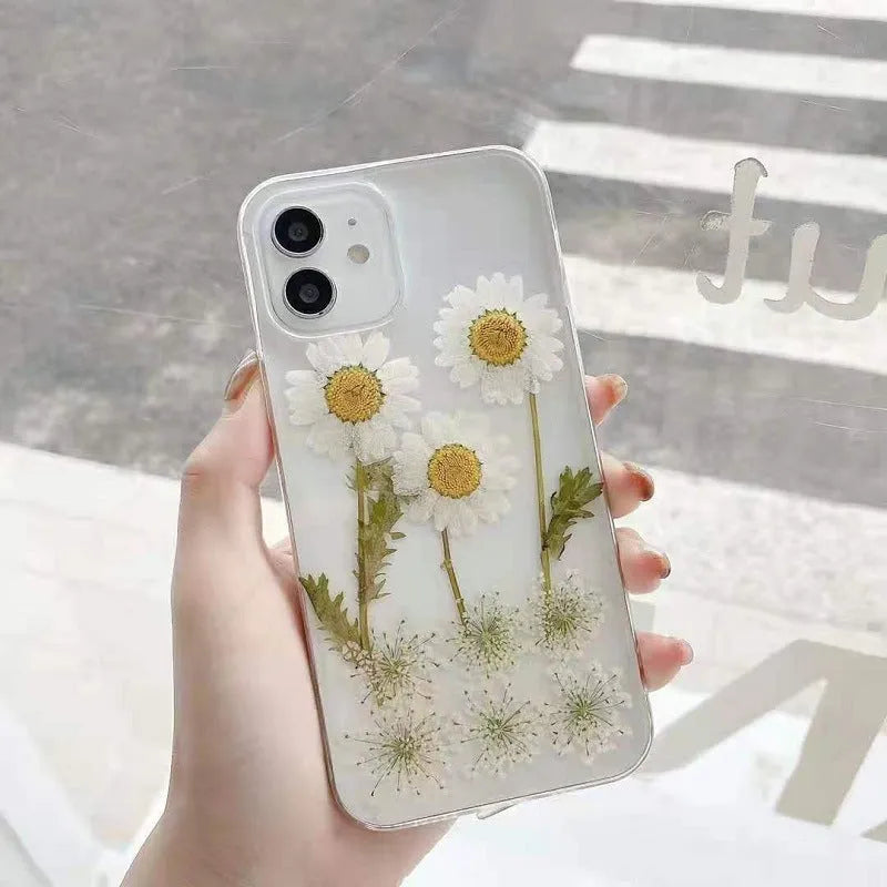 White TPU iPhone case with epoxy daisy floral pattern on back, shown on iPhone model