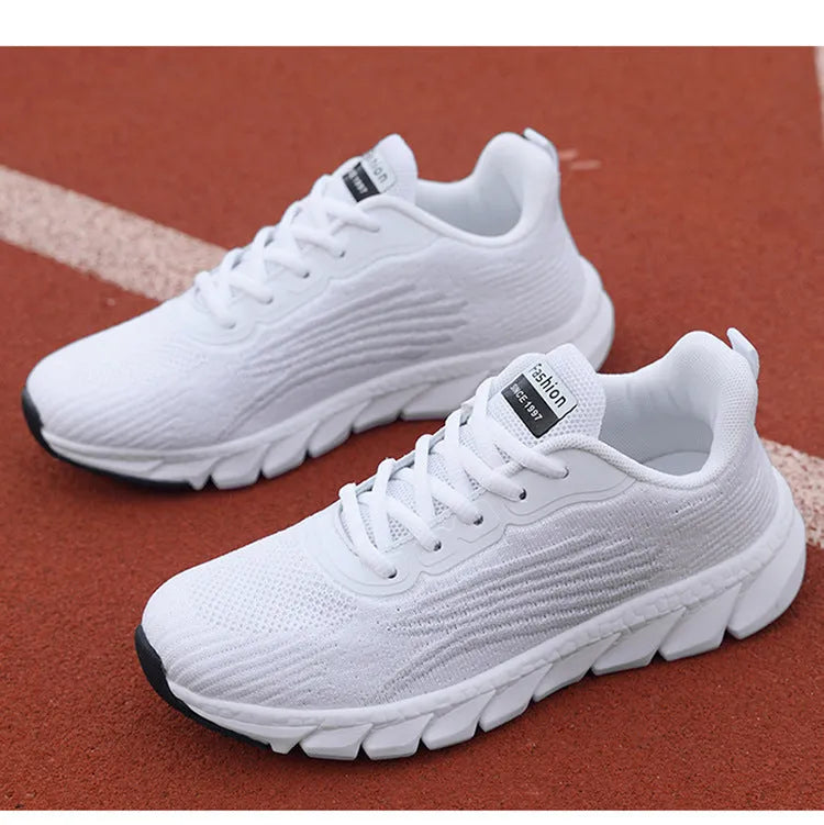 Flat running sneakers with cross-strap detail in black or white colours