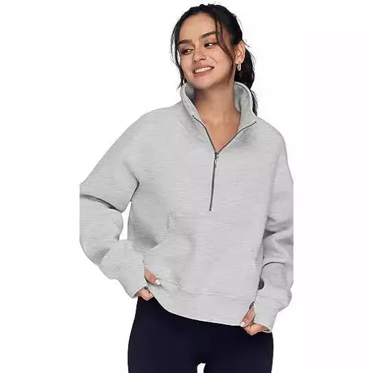 A woman wearing a loose-fitting apricot-coloured fleece-lined sweater with a lapel neckline and raglan sleeves.