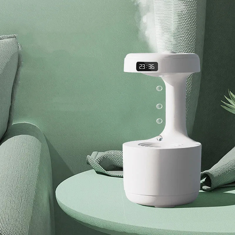 White columnar anti-gravity humidifier with LED clock display emitting mist on a wooden desk.