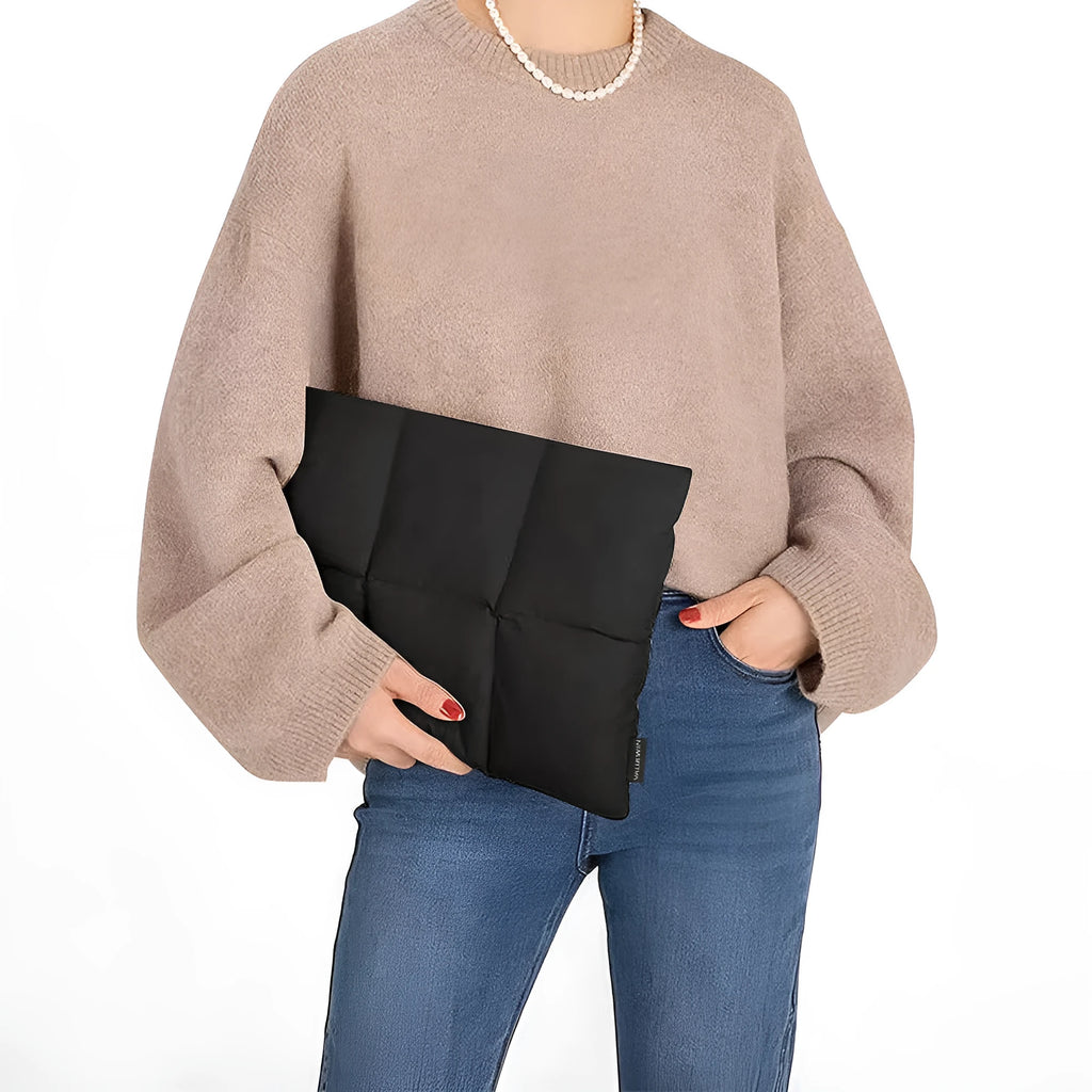 Soft fluffy polyester laptop sleeve in black with visible sewing thread detail, shown next to a laptop.