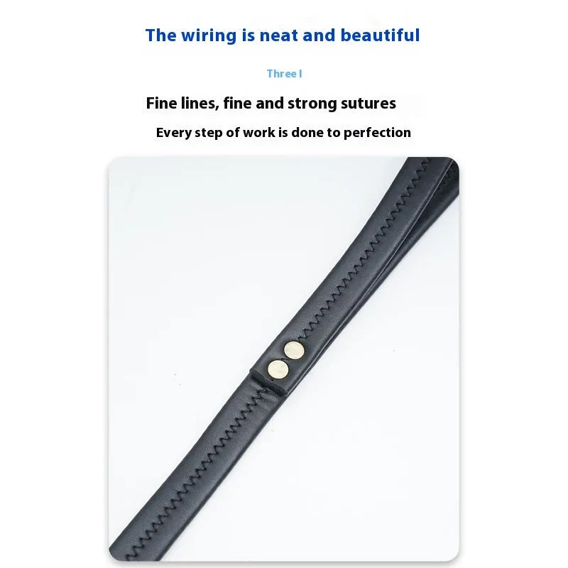 Black PU leather dog traction belt with metal chain ring on a wooden surface.