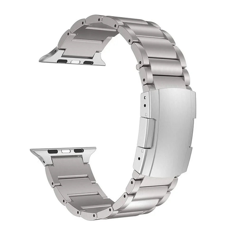 Black titanium metal Apple Watch band with a folding buckle on a table