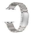 Black titanium metal Apple Watch band with a folding buckle on a table