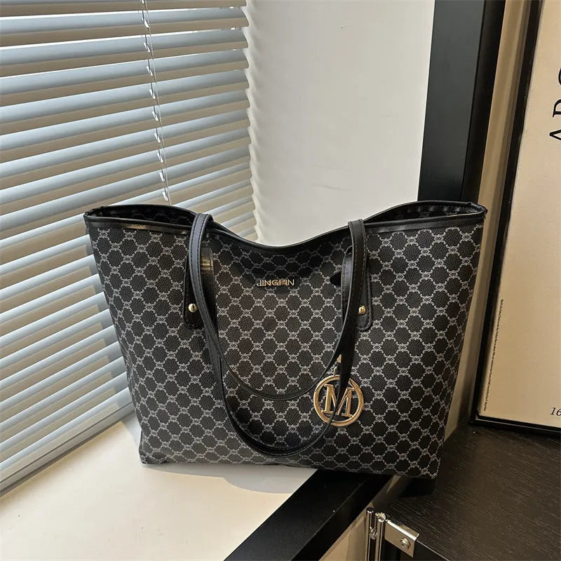 Soft PU leather ladies' shoulder bag in black showing contrast stitching and a top handle.