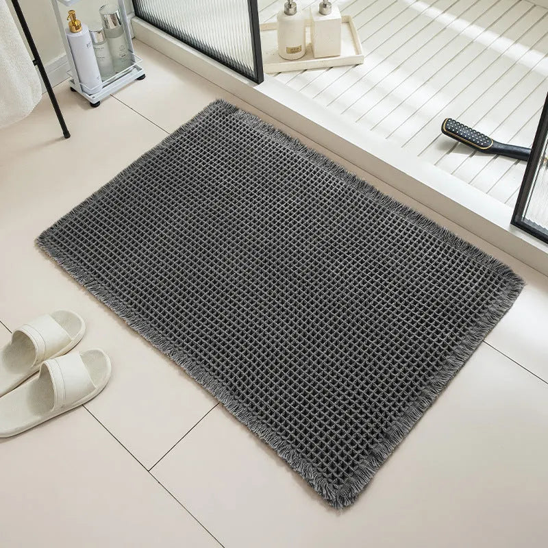 Checkered non-slip polyester bathroom floor carpet in a neutral colour on tiled floor.