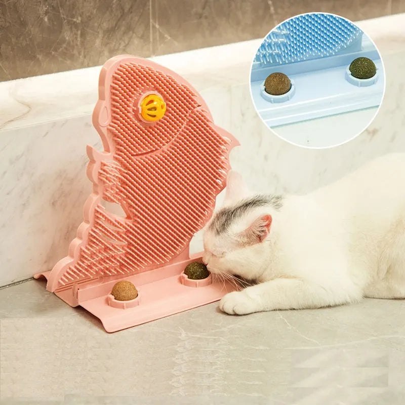 Blue plastic fish-shaped cat wall scratcher with brush, two green catnip balls, a bell, and a base.