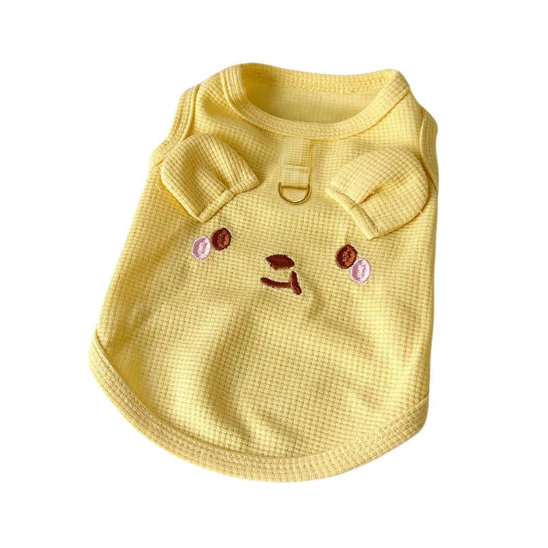 A yellow waffle-textured dog vest lying flat, showing its simple vest shape and knit pattern.