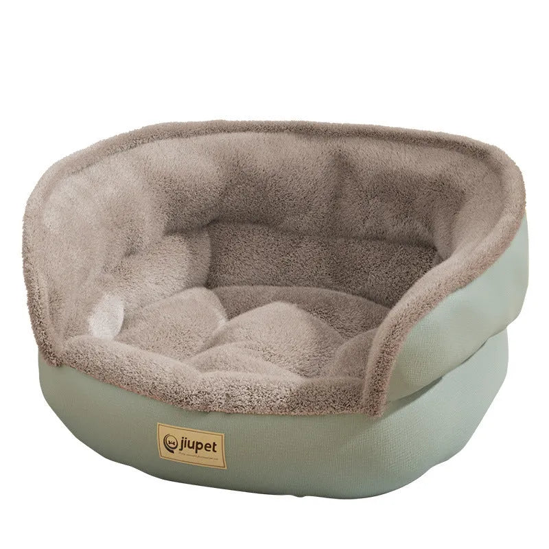 Green cloth sofa-style dog kennel with matching blanket, size M, on a wooden floor